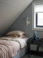 Et lyst og moderne interiør med Sam-tapet fra Boråstapeter på veggene. De subtile stripene skaper en harmonisk bakgrunn som på avstand kan fremstå som en ensfarget flate med dybde