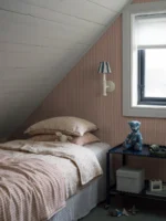 Et lyst og moderne interiør med Sam-tapet fra Boråstapeter på veggene. De subtile stripene skaper en harmonisk bakgrunn som på avstand kan fremstå som en ensfarget flate med dybde