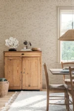Et lyst og trivelig rom med Boråstapeter Isidor på veggen, som tilfører en tidløs og botanisk stil til interiøret.