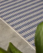 Rols uteteppe Kalahari Oat sea er et flattvevd teppe med et diskret, geometrisk mønster, som kombinerer naturlige beige- og havblå toner.