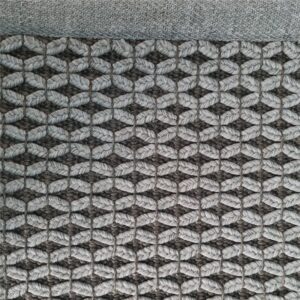 Et håndvevd teppe med en tydelig strukturert overflate. Teppet har en levende melering og en diskret kantavslutning