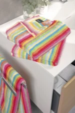 Fargerikt håndkle fra Cawö Lifestyle-serien med vertikale striper i alle regnbuens farger som rød, oransje, gul, grønn og blå.