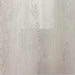 Titan Klikkvinyl Sirdal lagt i et stort, lyst rom. Gulvet har et naturlig treutseende med brede planker i en varm, lys beige nyanse som gir et autentisk preg.Sirdal