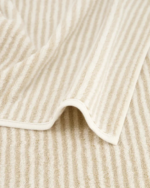 Cawö Two-Tone Stripe-håndkle i fargen Natur. Håndkleet har smale, vertikale striper i en varm beige nyanse og off-white.