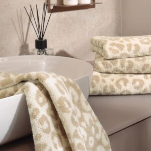 Et håndkle med beige og kremfarget leopardmønster over hele flaten.