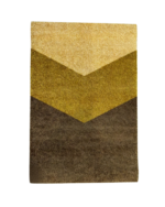 Moderne løper fra Lone Tepper med et geometrisk chevron-mønster i okergule og brune fargetoner.
