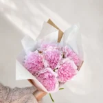 En fyldig bukett med kunstige, rosa peoner