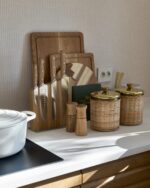 Riviera Maison fibertapet fra Storeys, med et tett, vertikalt mønster av fine striper i en lys beige nyanse som danner en taktil tekstilstruktur.